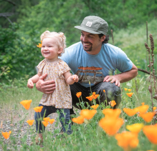 Rafa with his daughter in a field of wild flowers