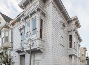 Exterior photo of David Ireland house in the Mission District of San Francisco. The house is a historical Victorian painted all white.
