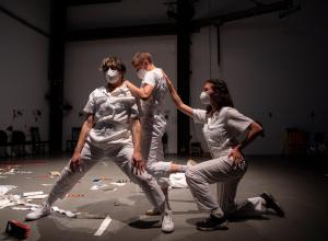 Three people dressed in white on a stage 